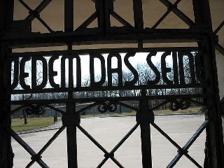 Buchenwald's main gate, with the slogan Jedem das Seine (literally, "to each his own," but figuratively "everyone gets what he deserves"). Photo: Motorfix on Wiki-Commons.